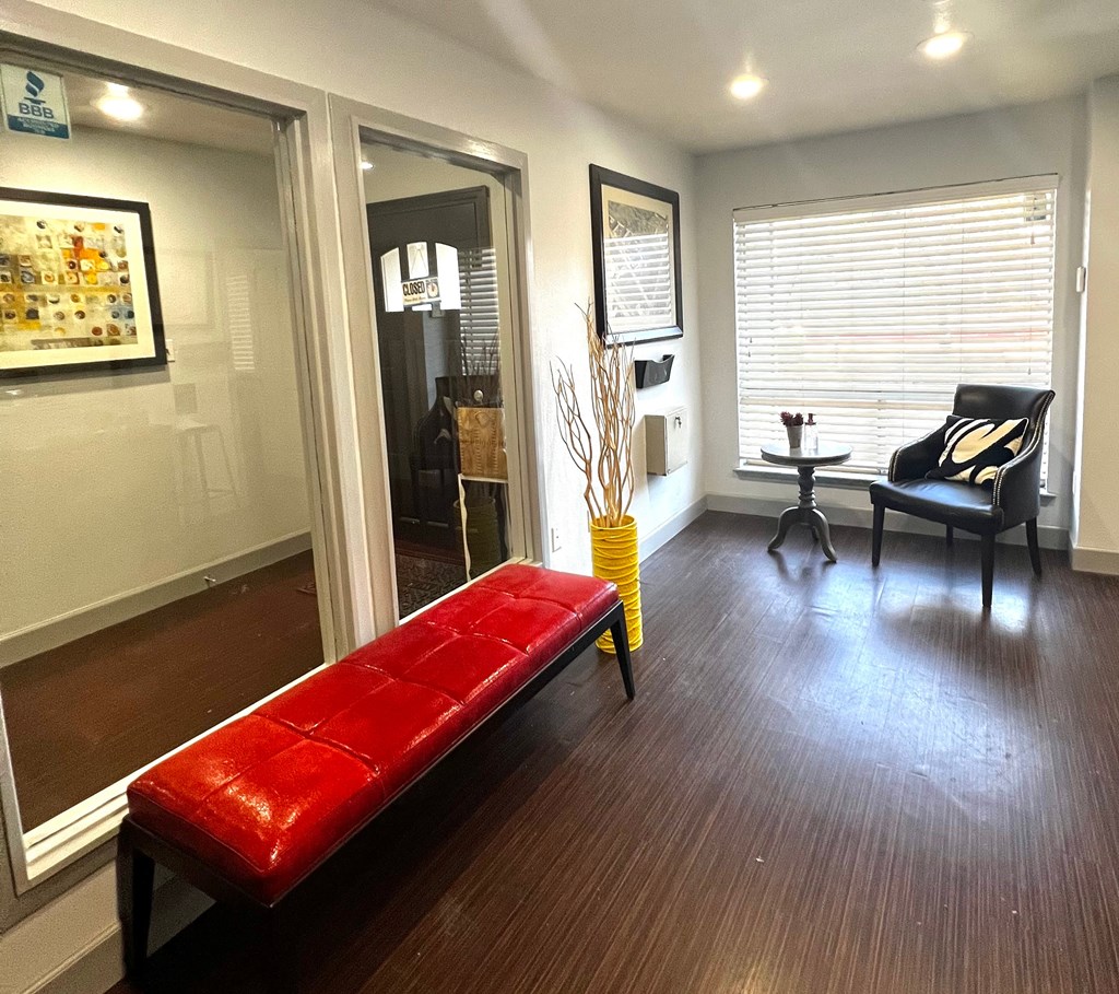 a living room with a red bench in front of a window