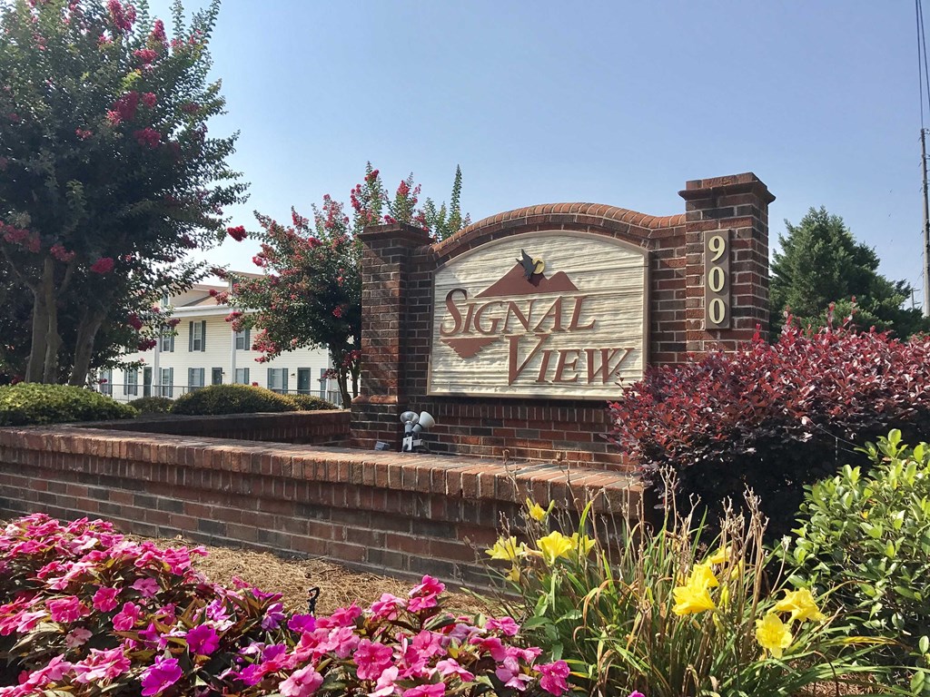 a sign for the sagalixix sign in front of a building with flowers