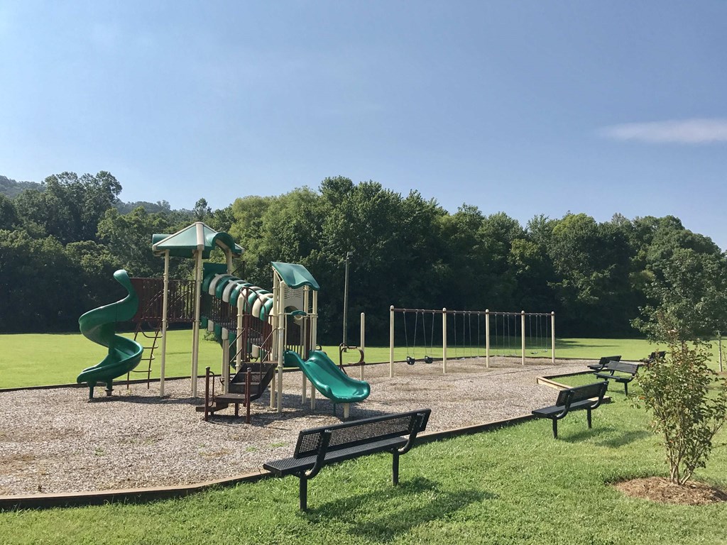 a playground with slides and benches in a park