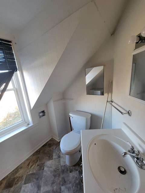 a bathroom with a toilet and a sink and a window