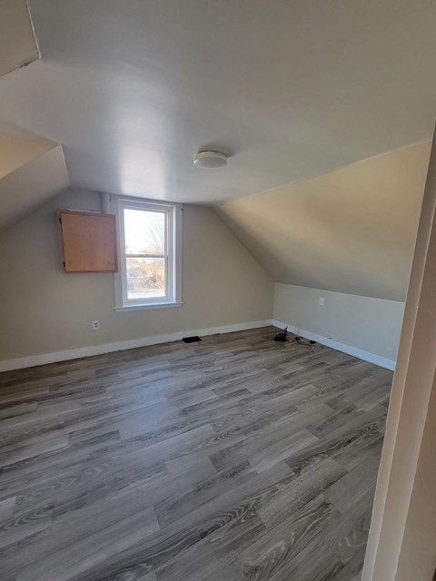 the upstairs living room with wood floors and a window