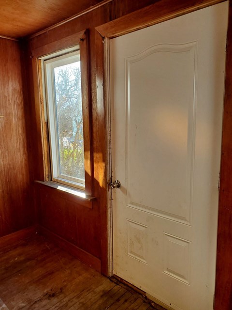 a room with a window and a white door