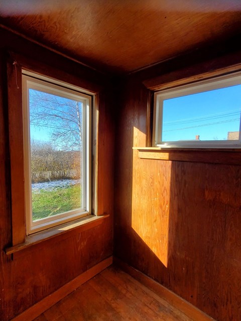 a small room with two windows and a blue sky