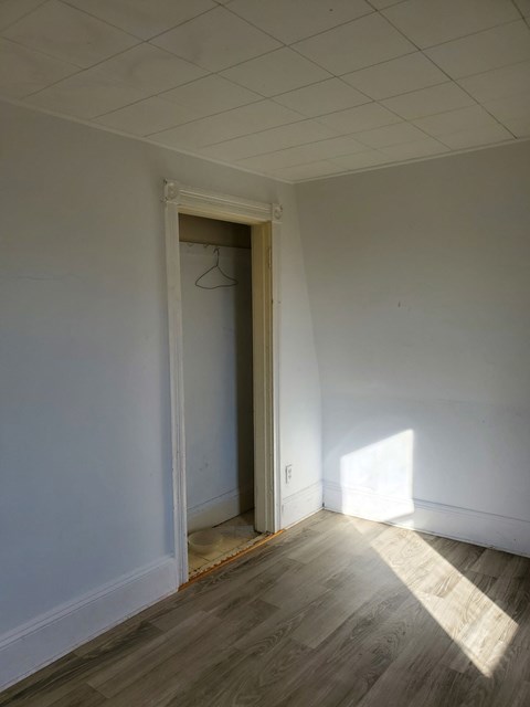a room with white walls and a door to a closet