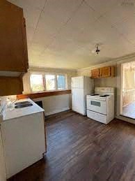 an empty kitchen with a stove and a refrigerator