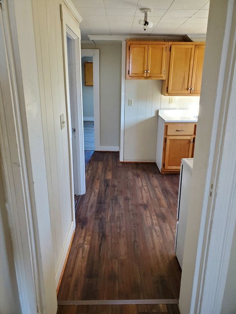 a small kitchen with wooden floors and wooden cabinets