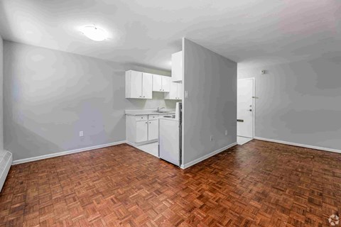 A kitchen area with a refrigerator, cabinets, and a countertop.