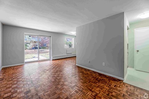 A room with a wooden floor and sliding glass doors.