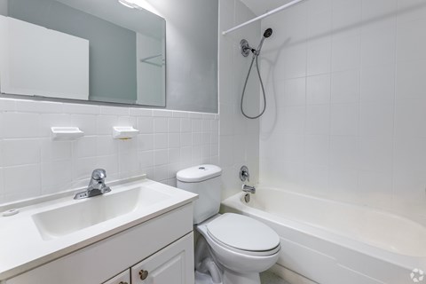 A white bathroom with a sink, toilet, and bathtub.