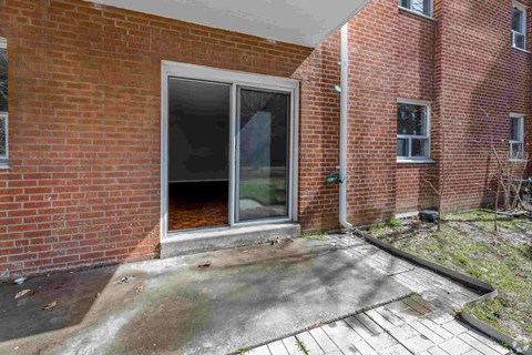 A red brick house with a white door and windows.