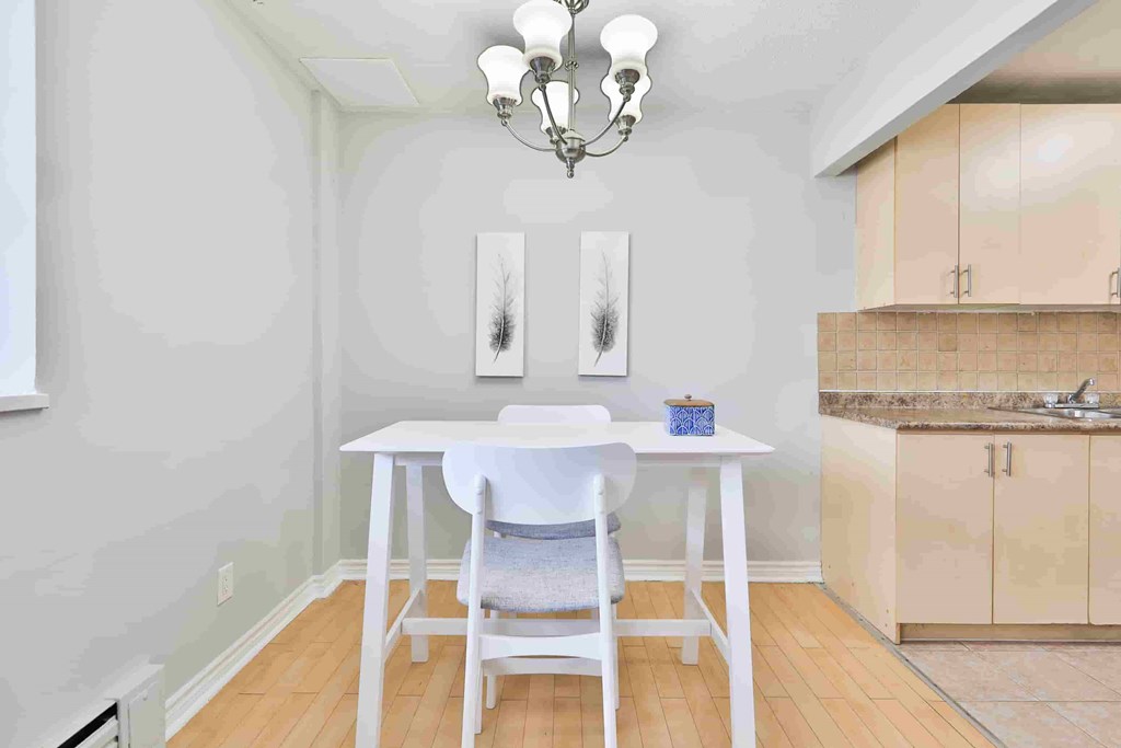 A dining room with a white table and chairs.