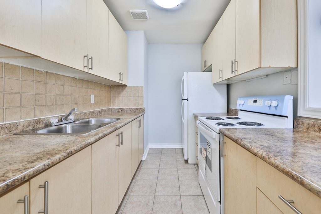 A kitchen with a white refrigerator and white stove.