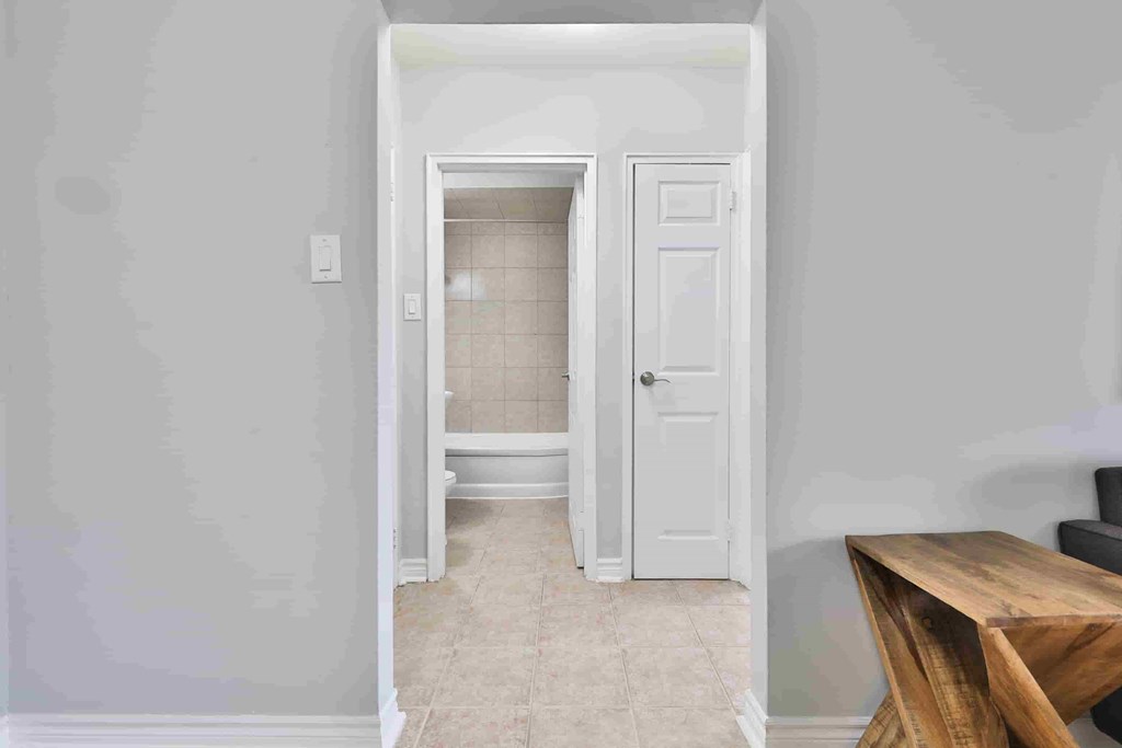 A white door is open to a bathroom.