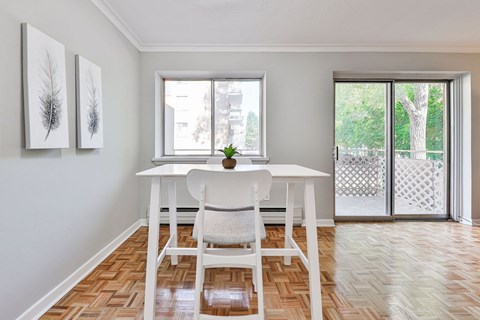 A dining room with a white table and chairs.