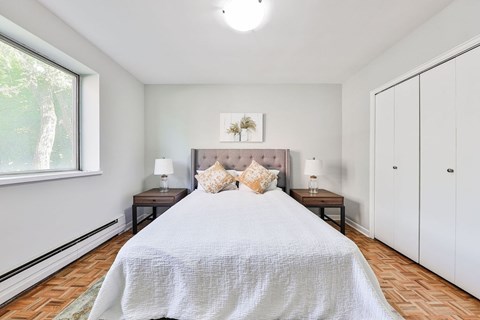 A bedroom with a large bed and a window.