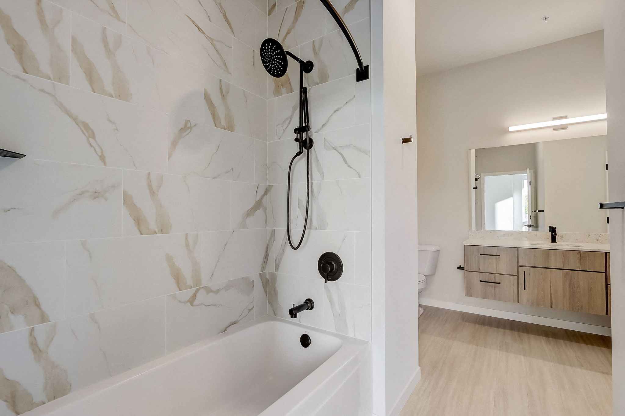 a bathroom with a tub and a shower and a sink