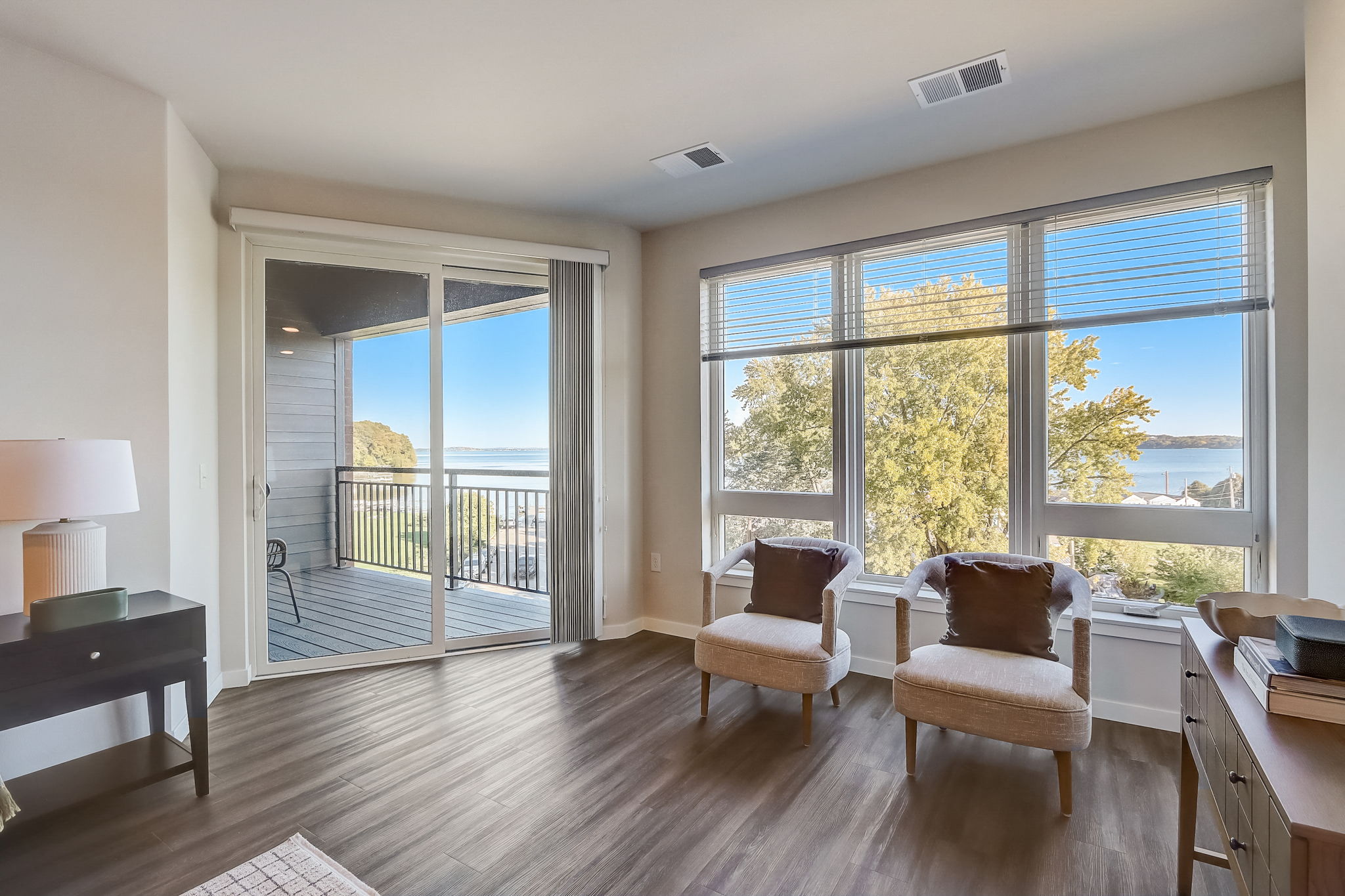 a living room with a view of the water and a desk and chairs