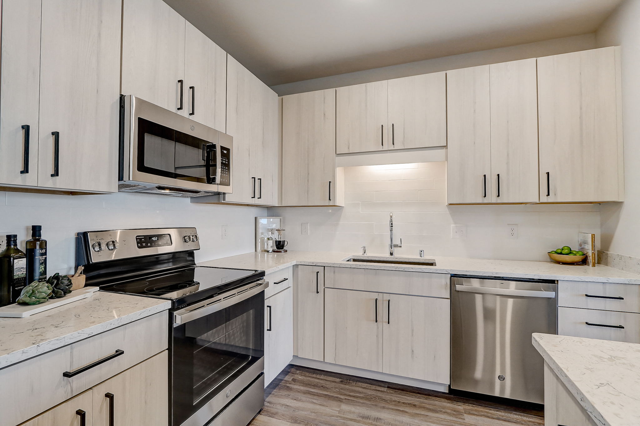 a kitchen with white cabinets and stainless steel appliances