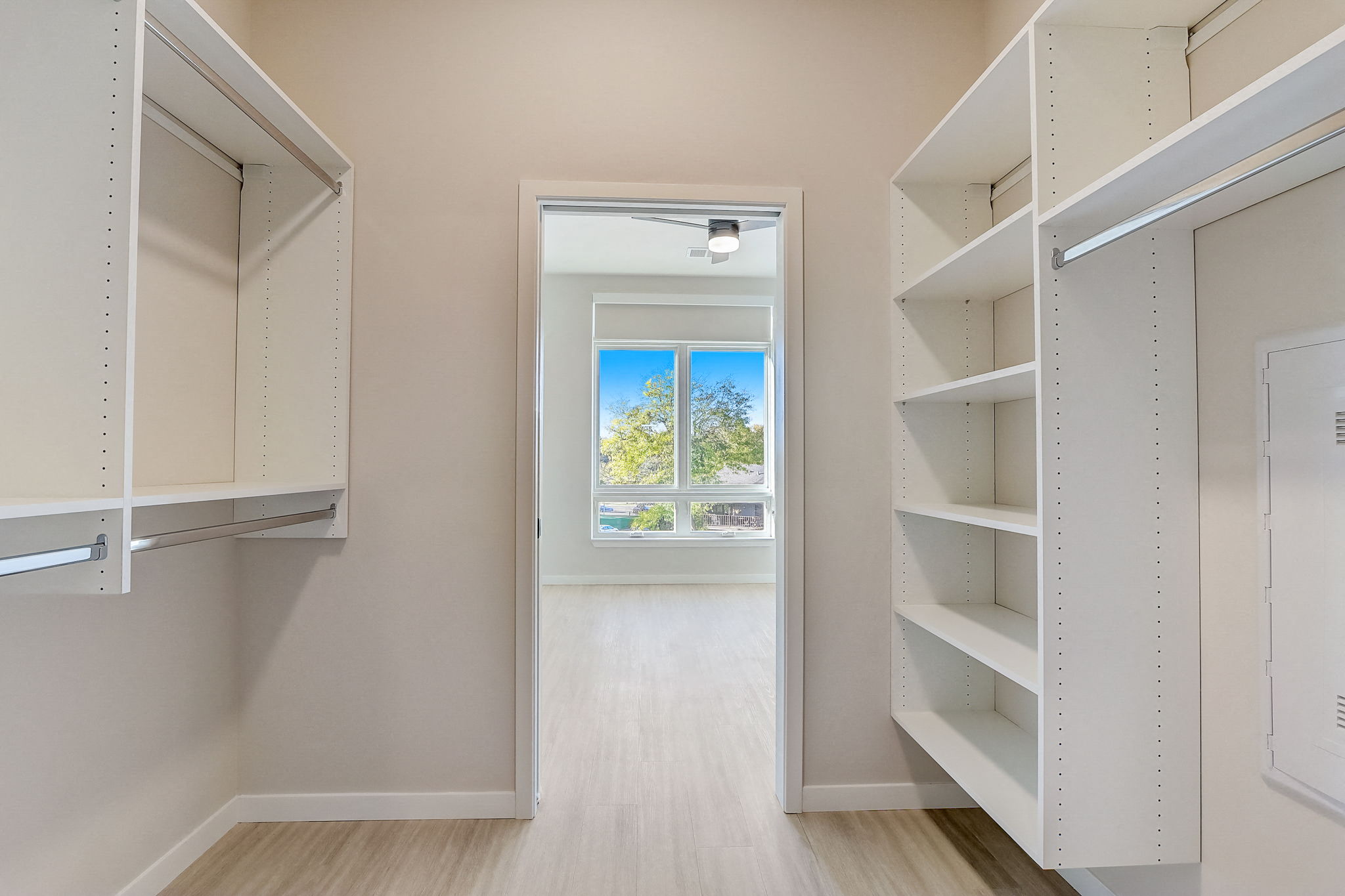a walk in closet with shelves and a window
