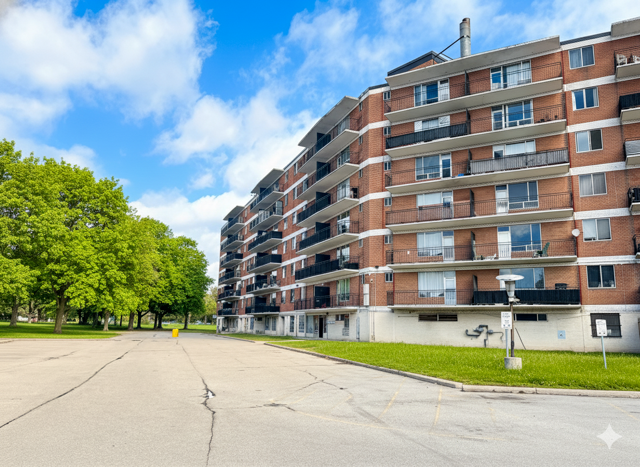 A large apartment building with a parking lot in front.