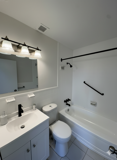 A white bathroom with a toilet, sink, and bathtub.