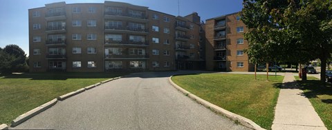 Apartment complex with a grassy area in front.