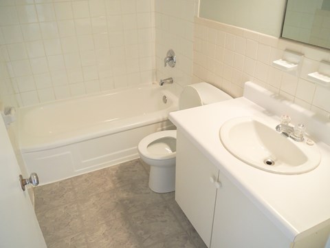 A white bathroom with a toilet, sink, and bathtub.