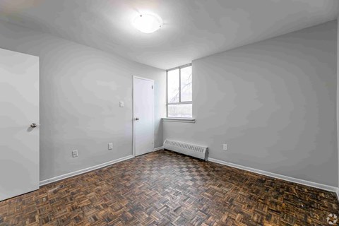A room with a wooden floor and a window.
