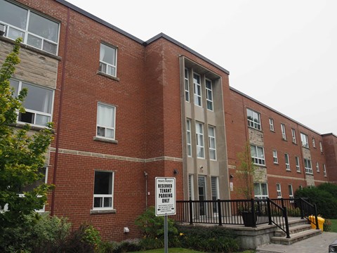 A red brick building with a sign that says "Reserve Parking Only".
