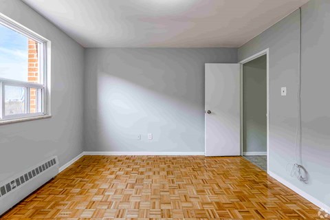 A room with a wooden floor and a window.