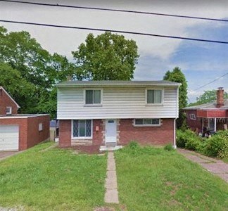 a white and brick house on a grassy yard