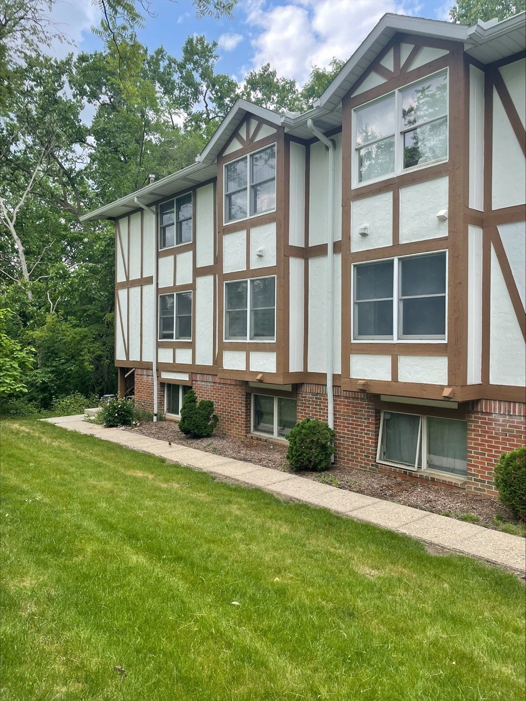 a side view of a building with a lawn and grass