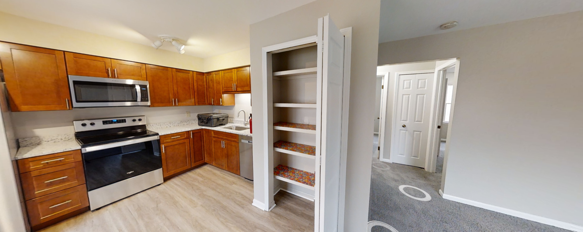 a kitchen with wooden cabinets and white appliances and a book shelf