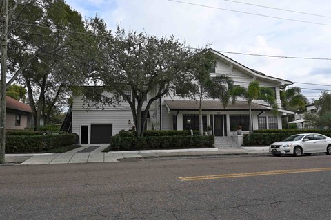 a white house with a car parked in front of it