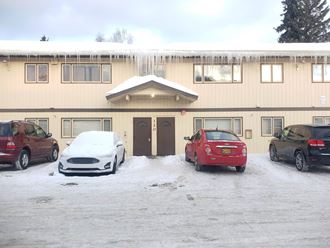 a building with icicles on the roof and cars parked in front