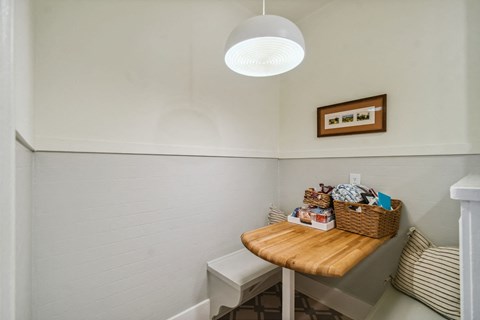 A small room with a basket on a table and a picture frame on the wall.