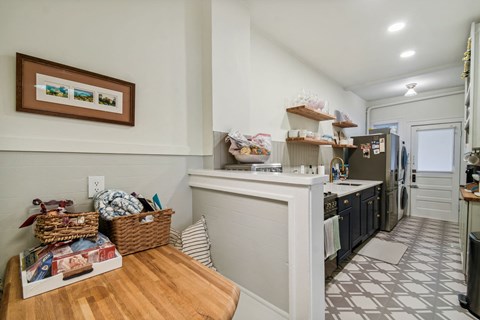 A kitchen with a white counter and a wooden table.