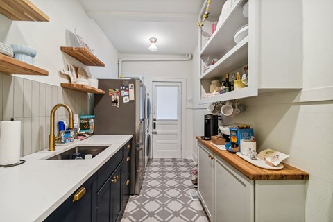 A kitchen with a white counter top and black cabinets.