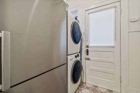 A modern washing machine is placed next to a white door.