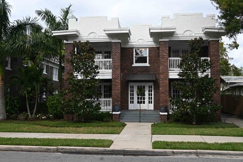 A white house with a brick facade and a white porch.