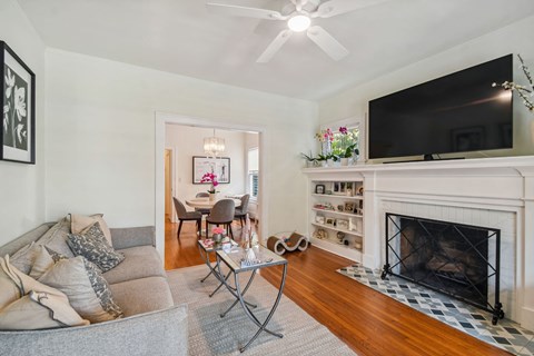 A living room with a grey couch and a fireplace.