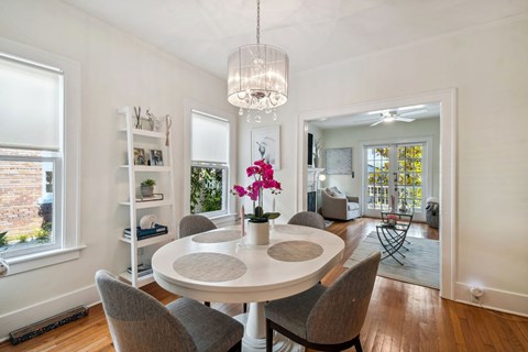 A dining room with a white table and chairs.