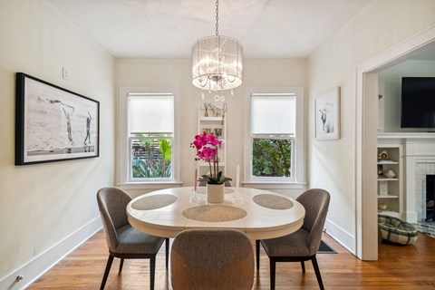 A dining room with a round table and chairs.