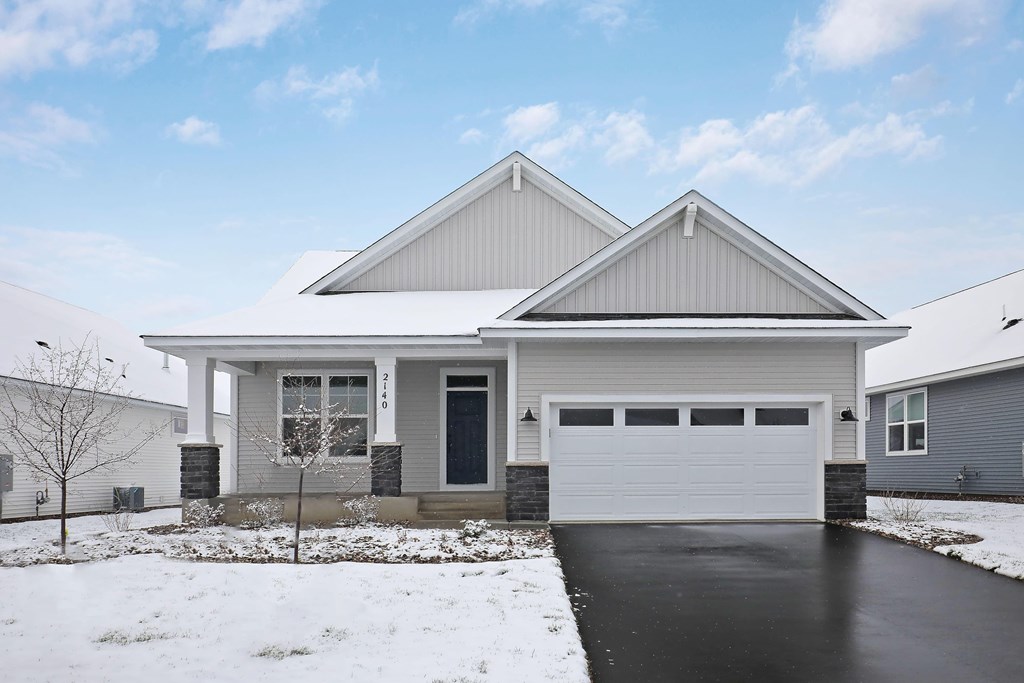 a white house with a garage door in the snow
