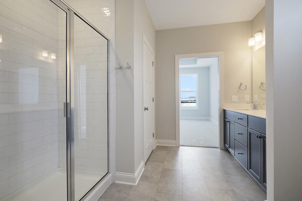 a bathroom with a shower and a sink and a mirror