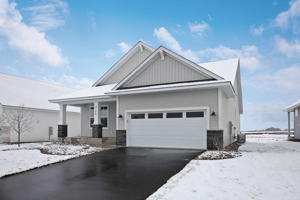a white house with a garage door in the snow