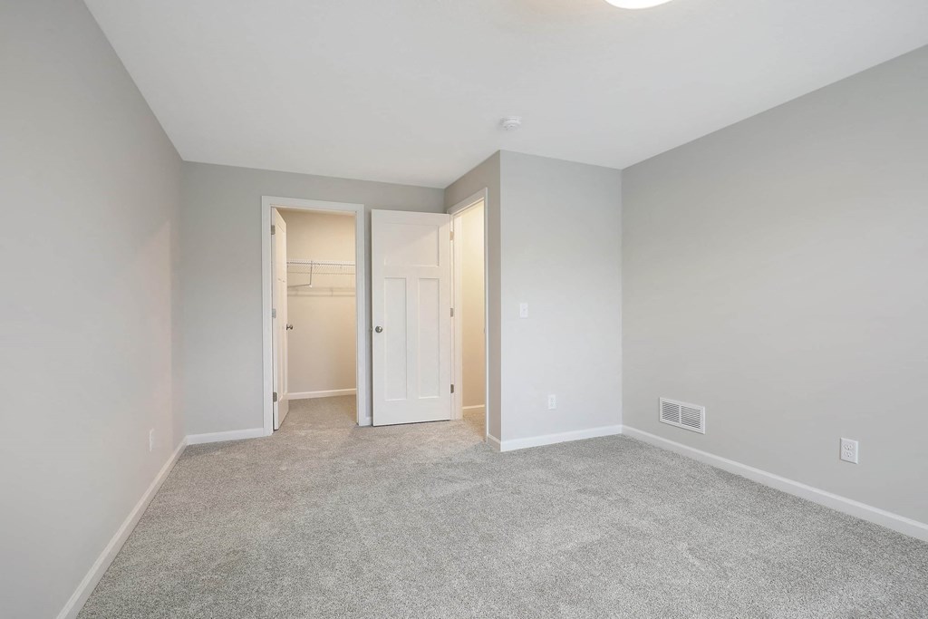 a living room with a carpeted floor and a closet
