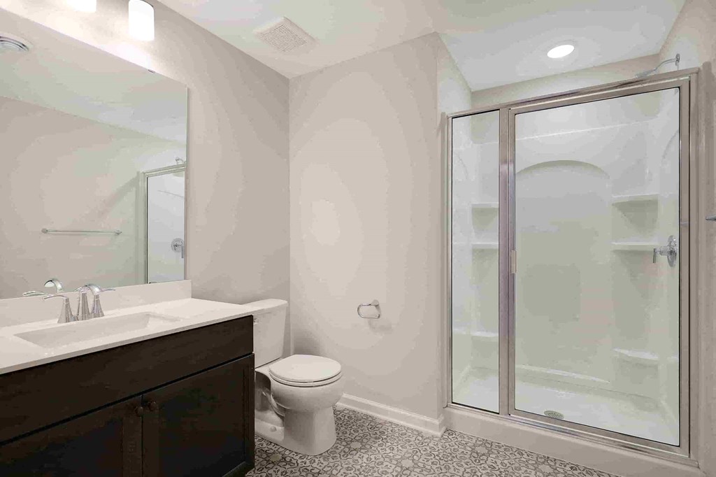 a bathroom with a shower and a sink and a toilet