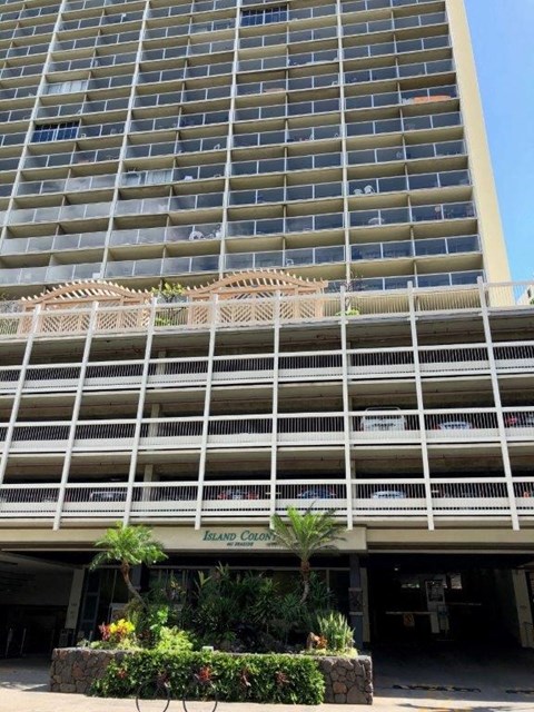 A large building with a balcony and a sign that says Island Colony.