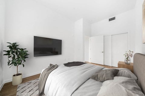 a bedroom with a bed and a television on the wall